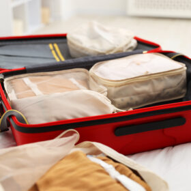 Packing cubes in suitcase on bed indoors, closeup
