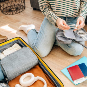 A suitcase packed with clothes, travel items and accessories representing preparation for a trip or vacation. Travel, organization and adventure planning concept