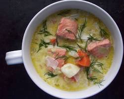 Bowl of creamy Finnish salmon soup topped with fresh dill sprigs, carrots, and tender salmon chunks.